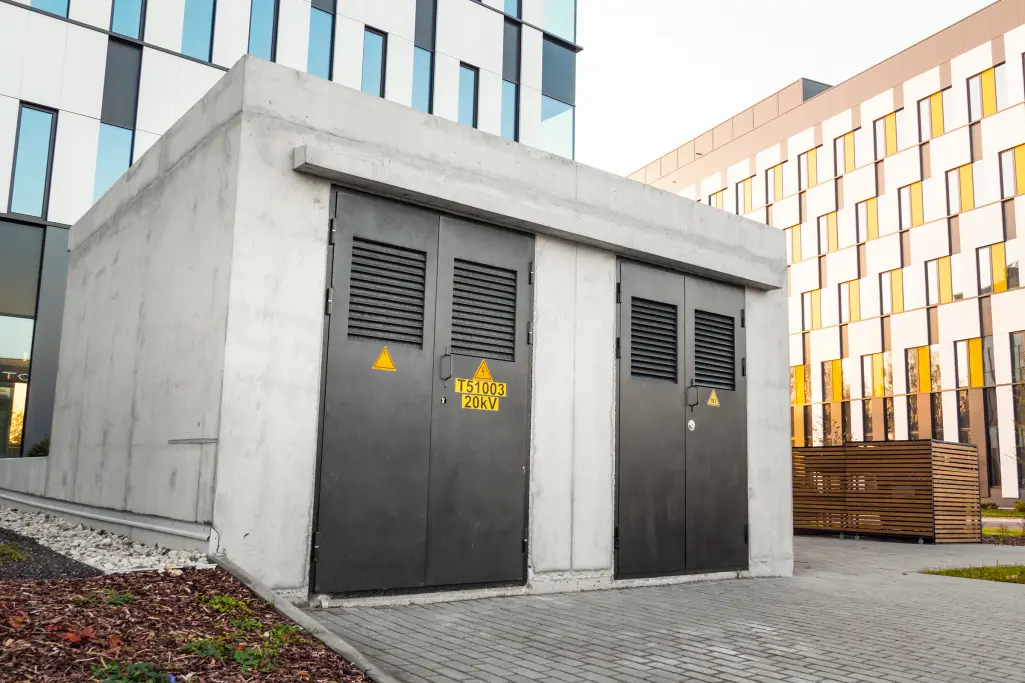 Kleines Gebäude zwischen Mehrfamilienhäusern aus Beton.
