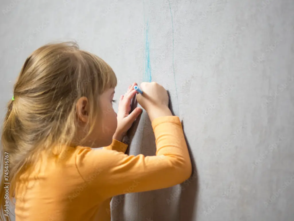 Frau streicht mit Farbrolle