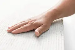 Eine Hand streicht prüfend über eine beschichtete Oberfläche